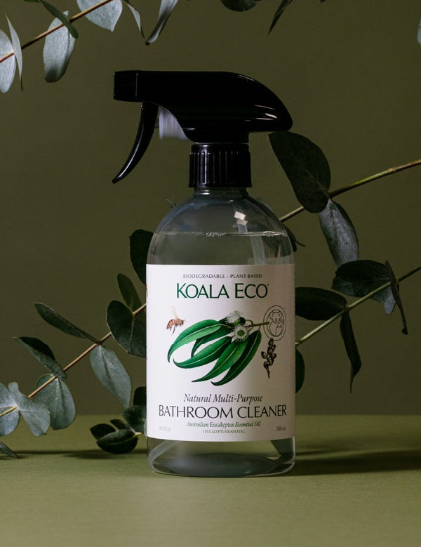 Koala Eco Bathroom Cleaner styled among eucalyptus branches on a deep green background