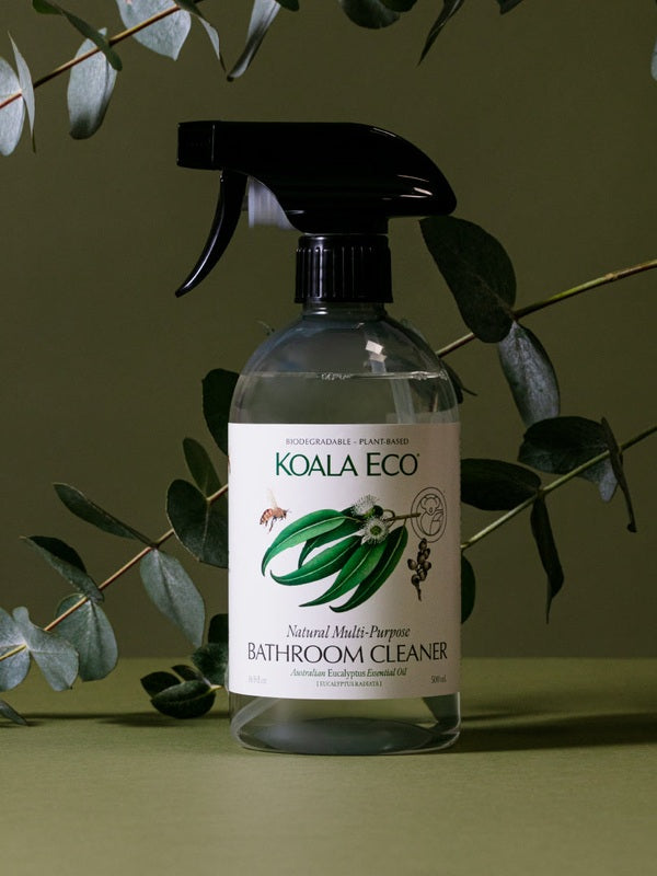 Koala Eco Bathroom Cleaner styled among eucalyptus branches on a deep green background