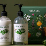 Koala Eco Eucalyptus and Rosemary Hand Care Gift Pack styled with greenery against a deep green background