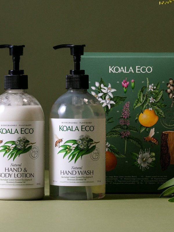 Koala Eco Eucalyptus and Rosemary Hand Care Gift Pack styled with greenery against a deep green background