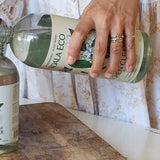 Koala Eco Glass Cleaner refill being poured into a reusable spray bottle