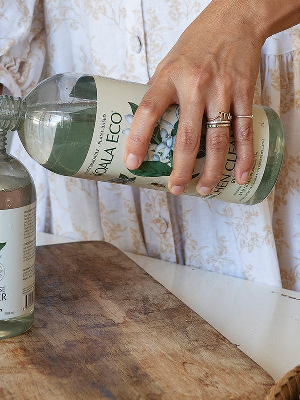 Koala Eco Glass Cleaner refill being poured into a reusable spray bottle