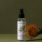 Koala Eco Rosalina and Peppermint Hand and Surface Spray styled with an orange banksia flower