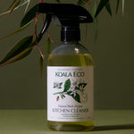 Koala Eco Multi-Purpose Kitchen Cleaner styled with Australian botanical branches on a deep green background