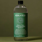 Koala Eco Oxygenated Bleach styled on a deep green background with soft botanical shadows