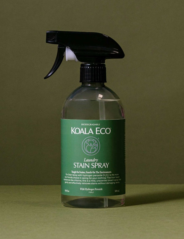 Koala Eco Laundry Stain Spray styled in botanical shadows on a deep green background