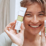 Woman holding Kolorex Horopito Skin Cream and wash beside her face