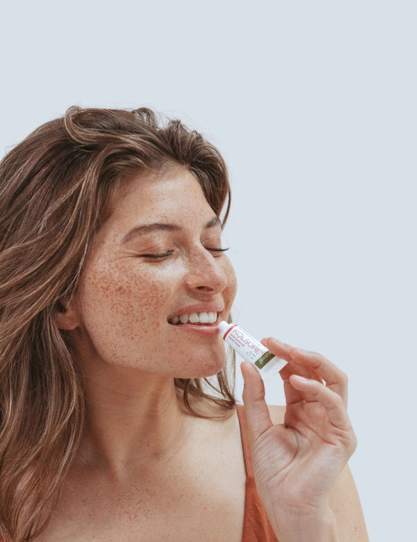 Woman applying Kolorex Kolsore Lip Ointment
