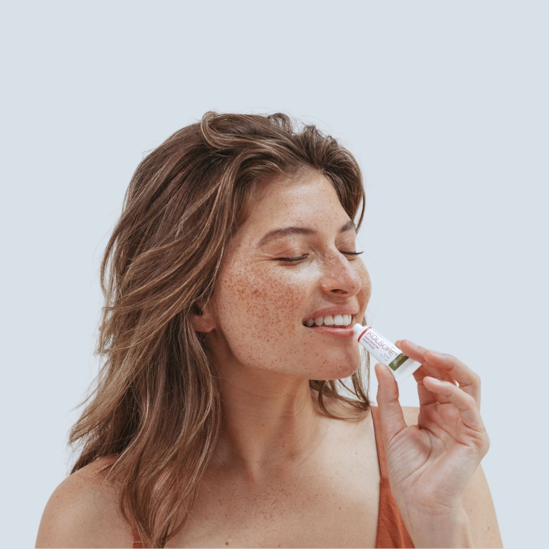 Woman applying Kolorex Kolsore Lip Ointment