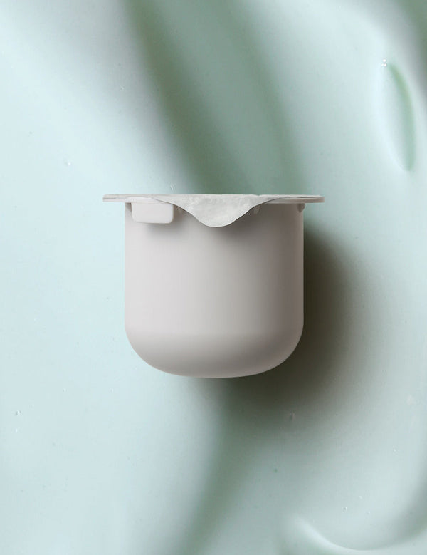 KORA Organics Active Algae Lightweight Moisturiser refill pod set against a soft green cream texture.