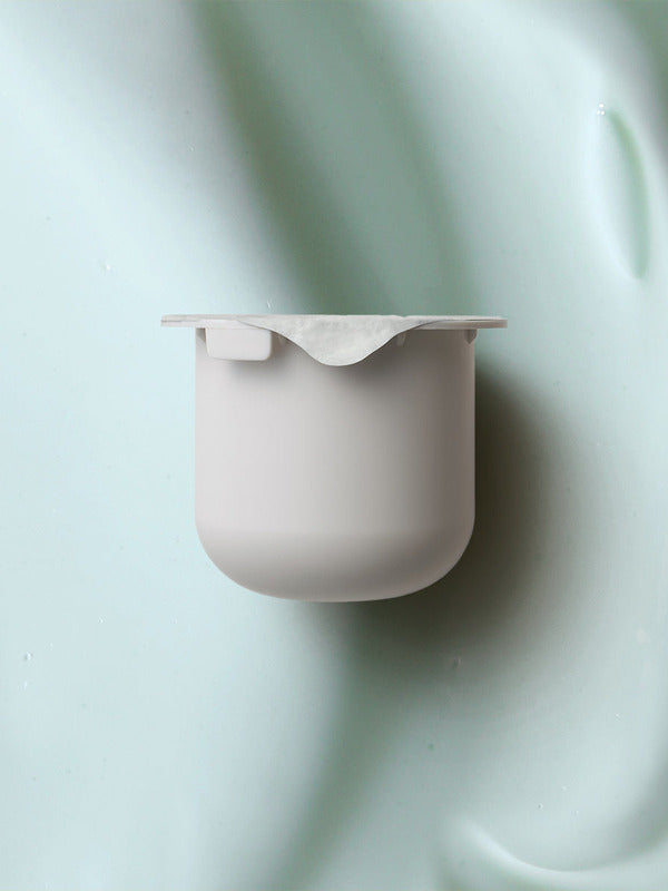 KORA Organics Active Algae Lightweight Moisturiser refill pod set against a soft green cream texture.