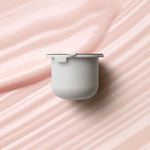 KORA Organics Berry Bright Vitamin C Eye Cream refill pod set against a soft pink cream texture.