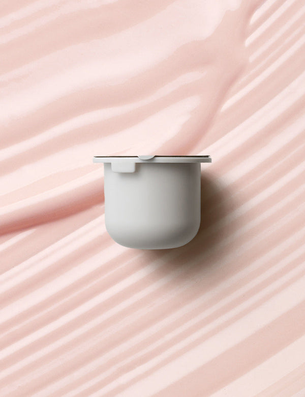KORA Organics Berry Bright Vitamin C Eye Cream refill pod set against a soft pink cream texture.