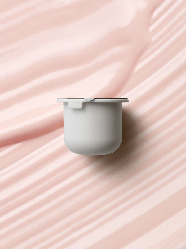 KORA Organics Berry Bright Vitamin C Eye Cream refill pod set against a soft pink cream texture.