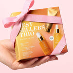 KORA Organics Best Sellers Trio: Hand holding the orange gift box tied with a pink ribbon.