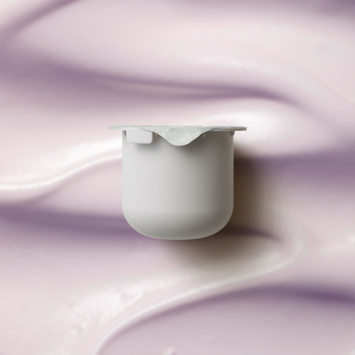 KORA Organics Plant Stem Cell Retinol Alternative Moisturiser refill pod on a soft lilac cream-texture background