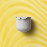 KORA Organics Turmeric Glow Moisturiser refill pod on a golden cream-texture background