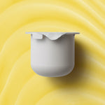 KORA Organics Turmeric Glow Moisturiser refill pod set against a golden yellow cream texture.