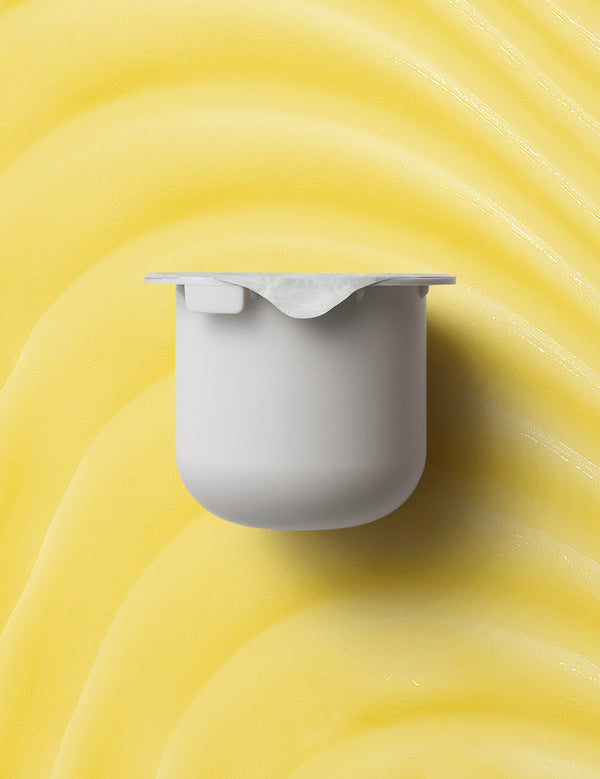 KORA Organics Turmeric Glow Moisturiser refill pod set against a golden yellow cream texture.