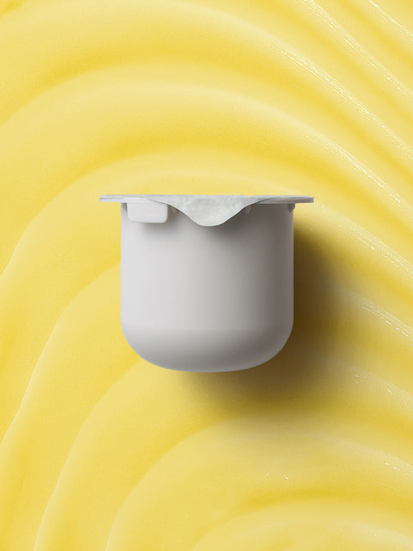 KORA Organics Turmeric Glow Moisturiser refill pod set against a golden yellow cream texture.