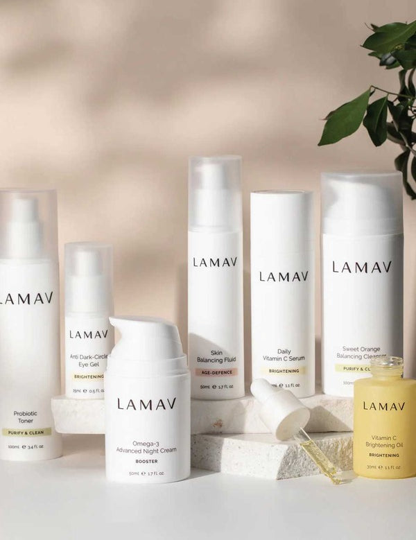 LAMAV Age-Defence skincare collection for oily and combination skin displayed on a pale surface with stones and a leafy branch.