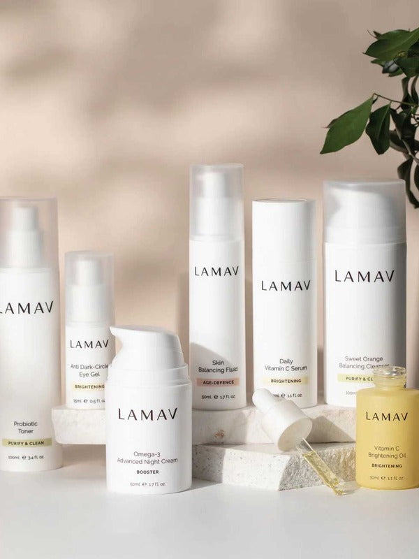 LAMAV Age-Defence skincare collection for oily and combination skin displayed on a pale surface with stones and a leafy branch.