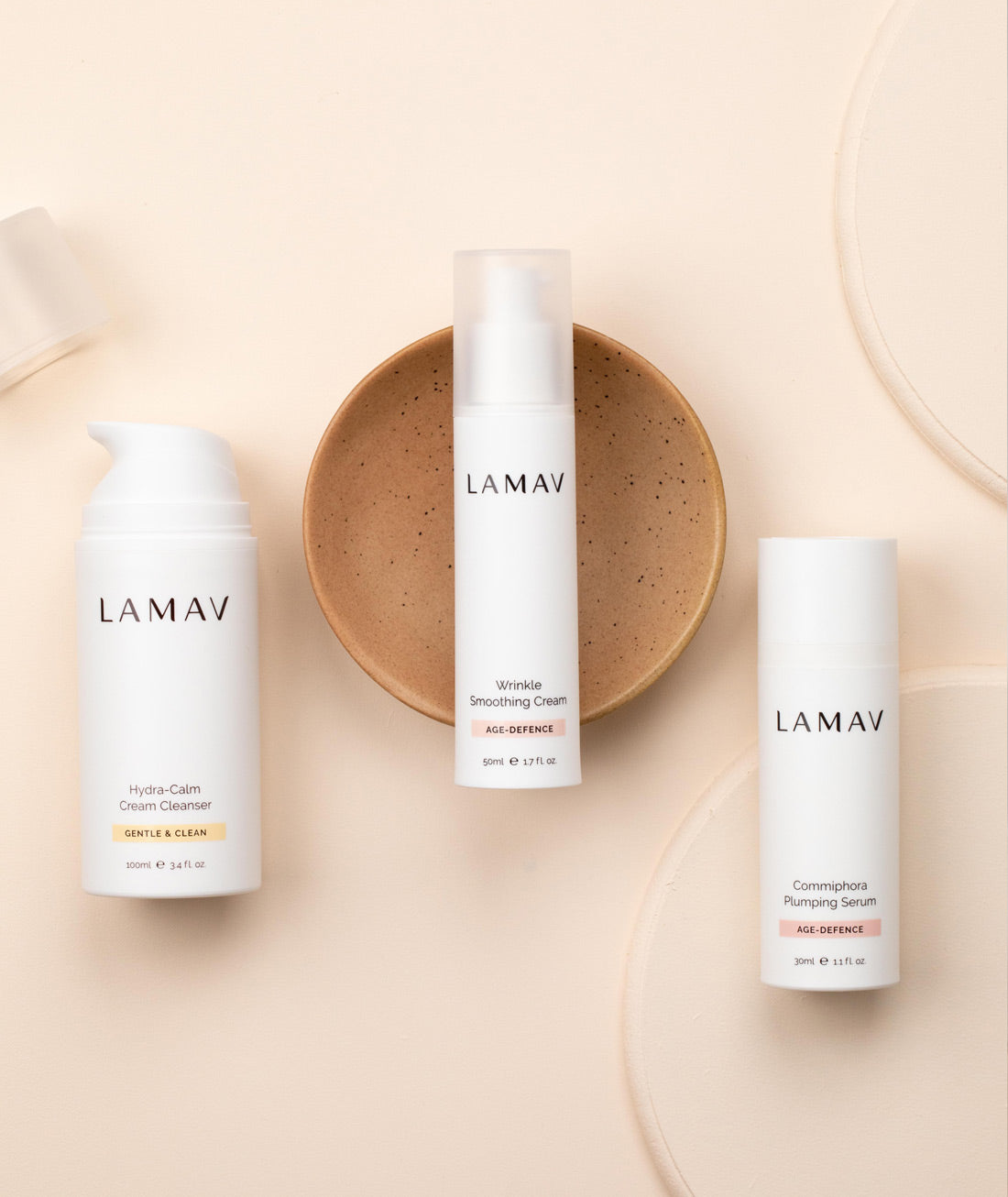 LAMAV Age-Defence skincare essentials arranged on a warm neutral surface