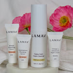 LAMAV Age-Defence Skin Discovery Pack products arranged on a tray with fresh pink flowers.