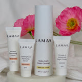 LAMAV Age-Defence Skin Discovery Pack products arranged on a tray with fresh pink flowers.