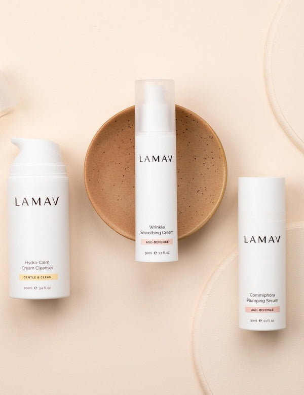 LAMAV Age-Defence Skin Discovery trio on peach, with Hydra-Calm Cream Cleanser, Wrinkle Smoothing Cream and Commiphora Plumping Serum.