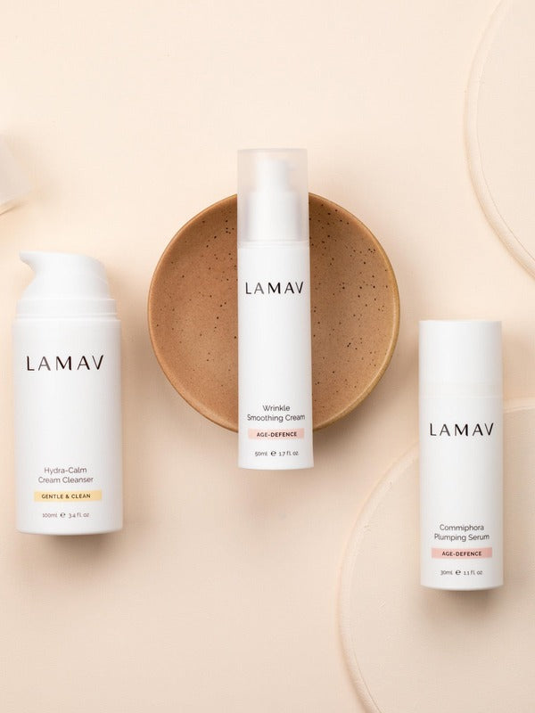 LAMAV Age-Defence Skin Discovery trio on peach, with Hydra-Calm Cream Cleanser, Wrinkle Smoothing Cream and Commiphora Plumping Serum.