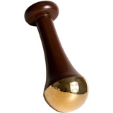 The LAMAV Ayurvedic Kansa Wand features a brown handle with a flared design and a rounded, shiny gold-colored tip, ideal for facial massage to support lymphatic drainage and promote radiant, healthy skin.