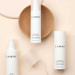 Three white LAMAV Hydration Skin Discovery products arranged around a tan ceramic dish on a soft peach background.