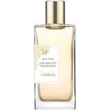 A clear glass bottle of Lavanila The Healthy Fragrance EDT Pure Vanilla 50ml with a gold cap features gold floral accents and branding on the label. This vegan perfume’s pale yellow liquid is visible inside.