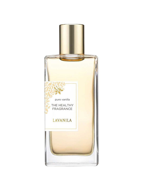 A clear glass bottle of Lavanila The Healthy Fragrance EDT Pure Vanilla 50ml with a gold cap features gold floral accents and branding on the label. This vegan perfume’s pale yellow liquid is visible inside.
