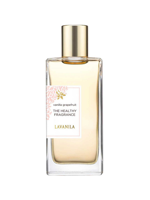 A clear glass bottle of Lavanila The Healthy Fragrance EDT Vanilla Grapefruit 50ml features a gold cap, light amber liquid, and a label with a pale pink floral accent, highlighting its natural scent.