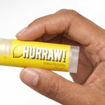 Hand holding Hurraw! Organic Lip Balm - Lemon 4.8g
