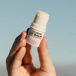 Little Urchin cherry and Kakadu plum lip balm held in hand