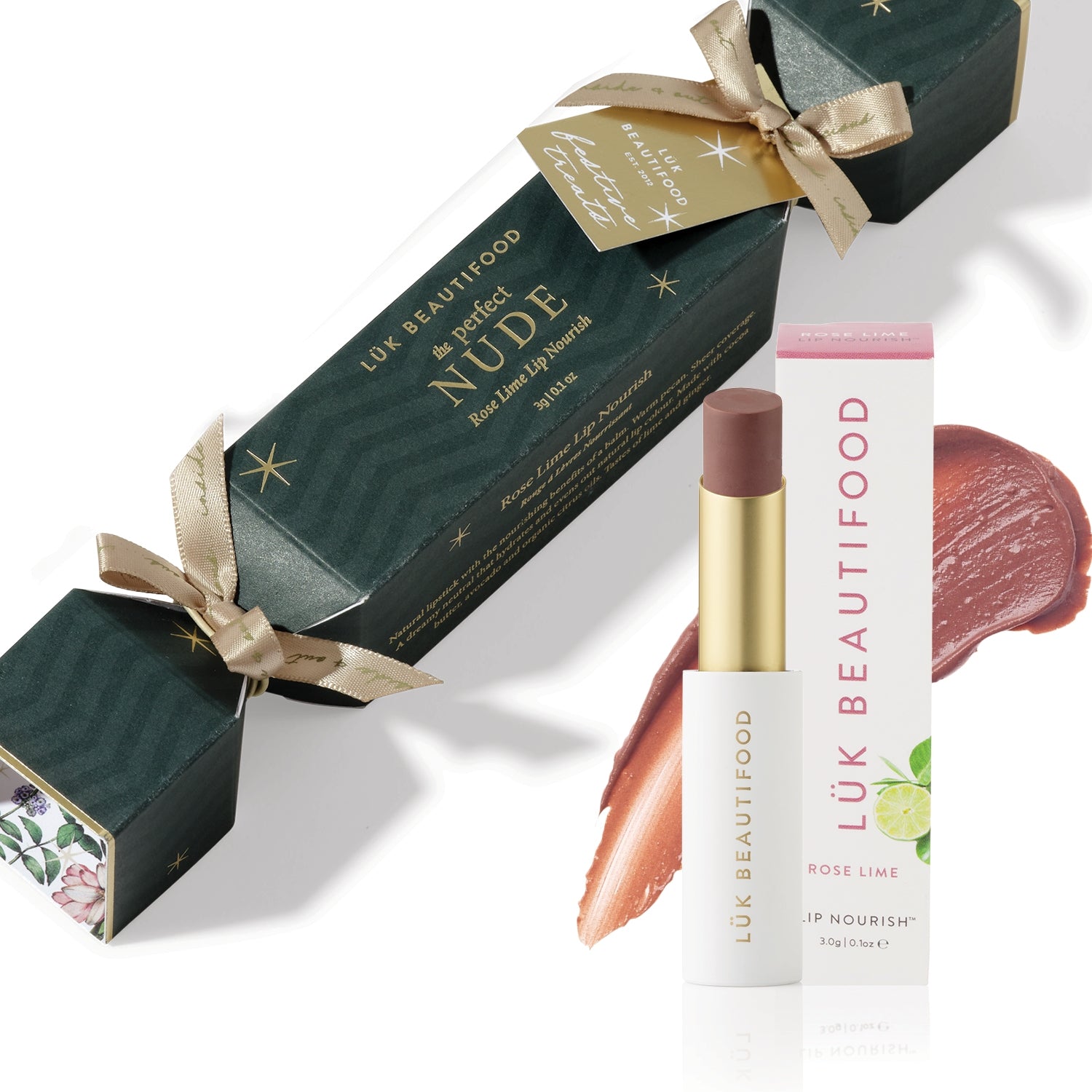 The Perfect Nude Bon Bon: dark green Christmas cracker with gold ribbons, Rose Lime Lip Nourish lipstick, its white carton and a warm nude colour smear.