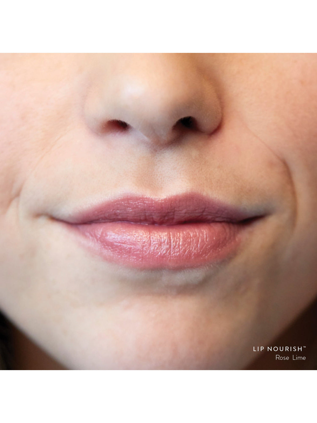 Close-up of lips wearing Rose Lime Lip Nourish, showing a sheer warm nude-rose colour with a subtle glossy finish.
