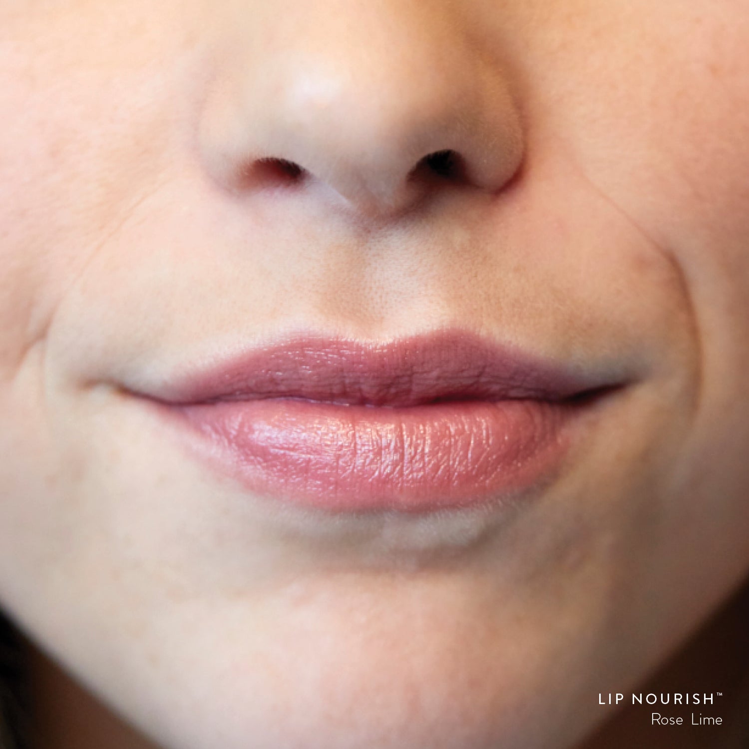 Close-up of lips wearing Rose Lime Lip Nourish, showing a sheer warm nude-rose colour with a subtle glossy finish.