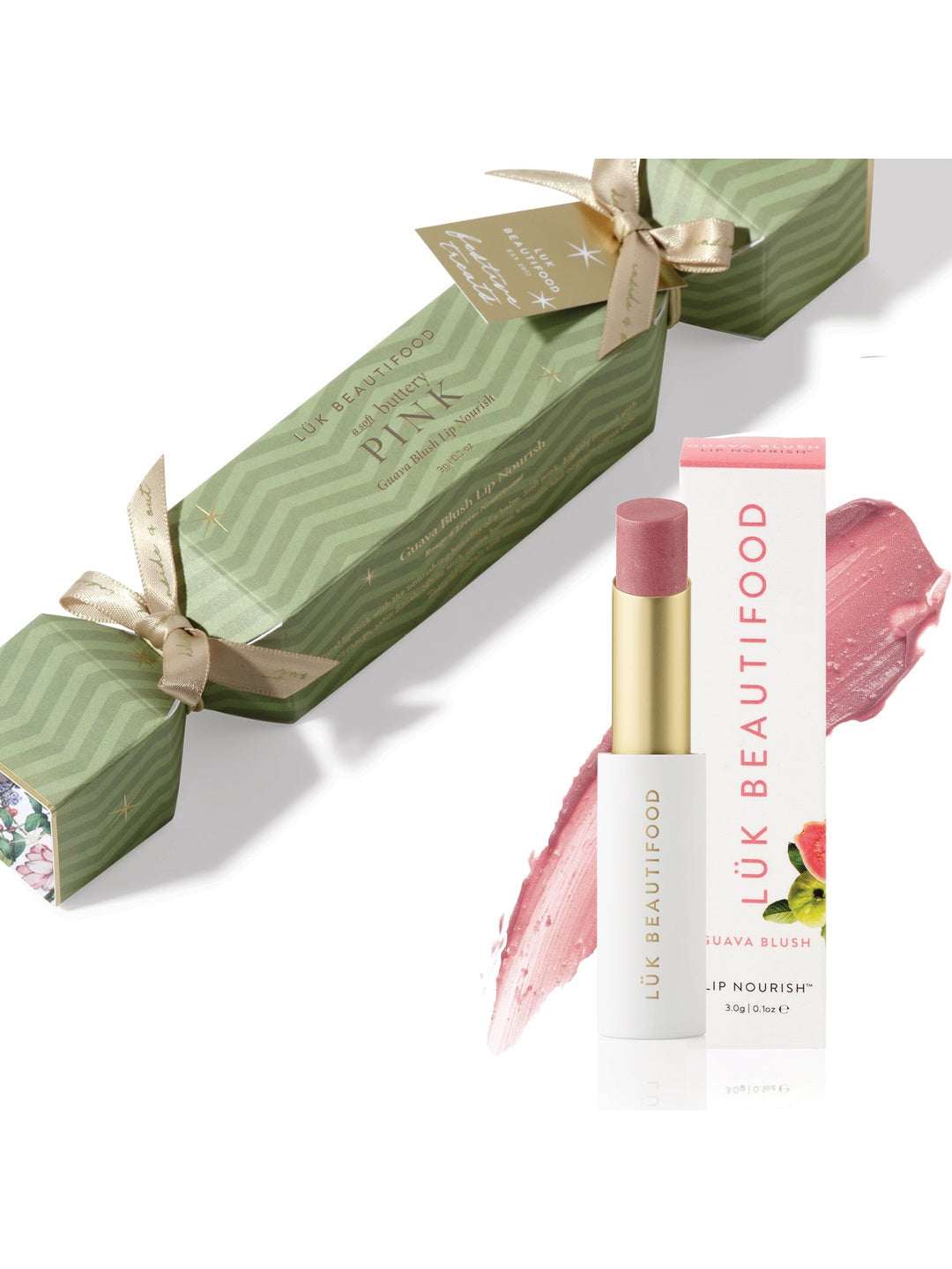 Soft Buttery Pinks Bon Bon: light green Christmas cracker with gold ribbons, Guava Blush Lip Nourish lipstick, its white carton and a soft pink colour smear.