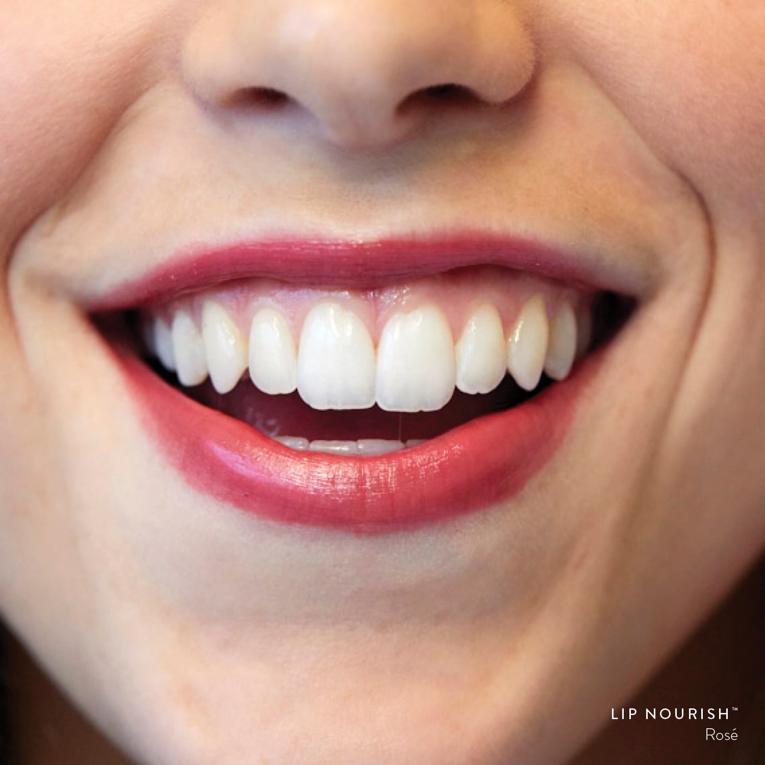 Close-up of a smile wearing Rosé Lip Nourish, showing a sheer wine-red lip colour with a glossy finish.