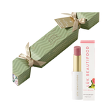 Luk Beautifood Bon Bon Guava Blush Lipstick Cracker on white: light green Christmas cracker tied with gold ribbons, alongside an open pink lipstick and its white carton.