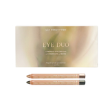 Luk Beautifood Luminous Eye Crayon Duo in Golden Olive: a gold-green gift box above two wooden eye crayons in Champagne and Olive.