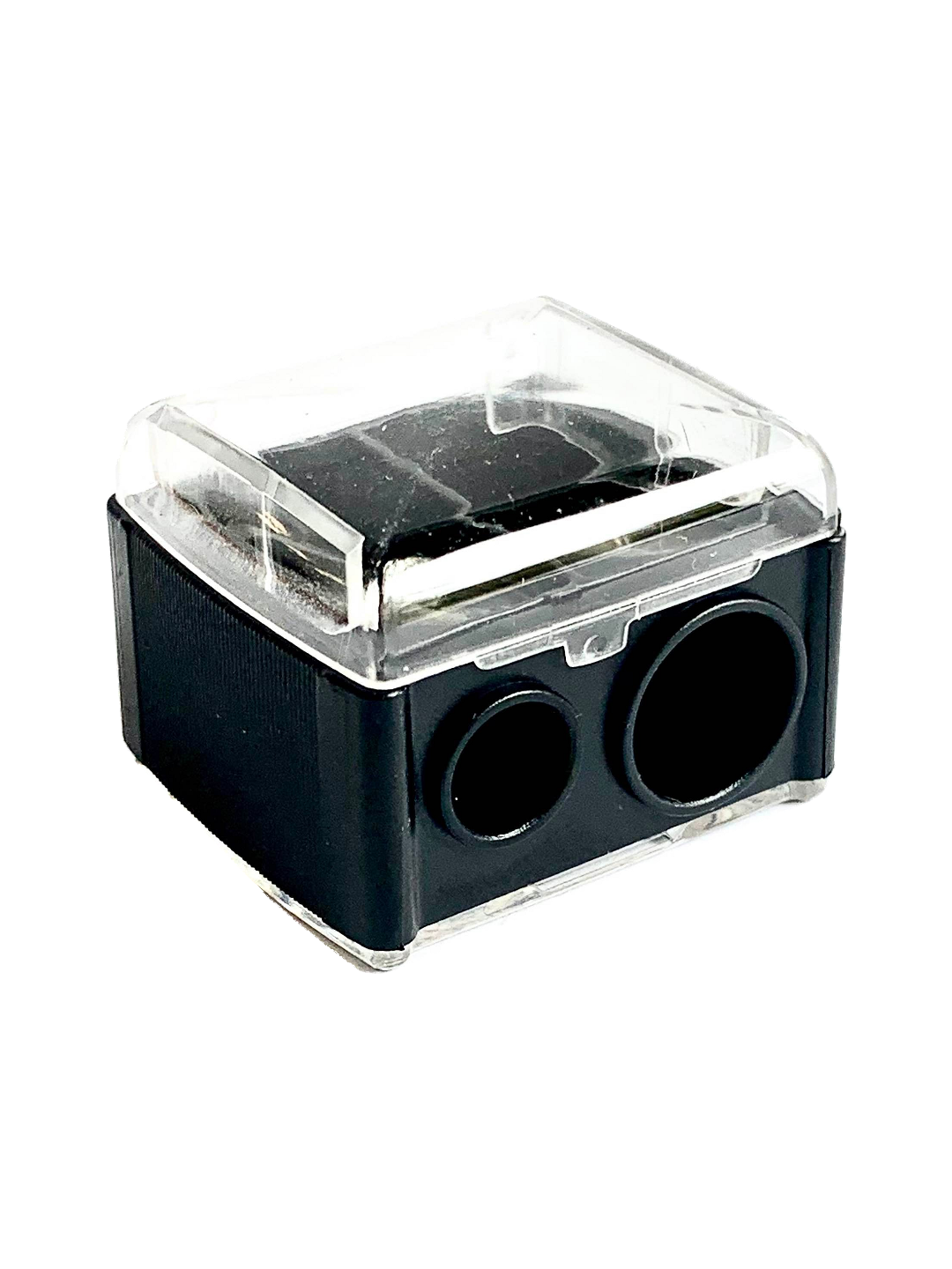 Black rectangular Luk Beautifood lip-crayon sharpener with a clear lid and two circular sharpening holes of different sizes.
