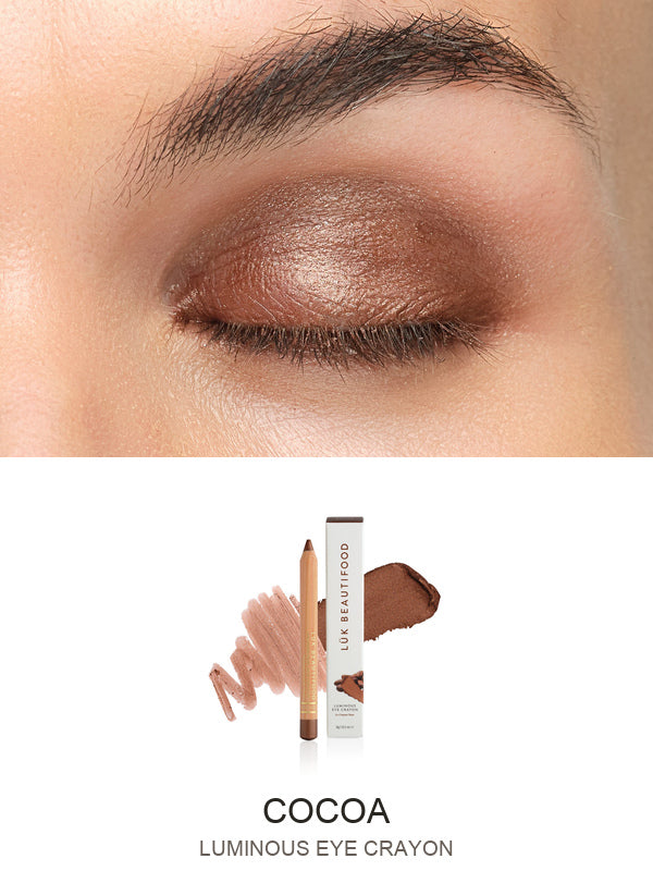 Luk Beautifood Luminous Eye Crayon in Cocoa: close-up of the shade on an eyelid above the matching crayon, carton and pigment swatch. Cocoa is labelled at the bottom.