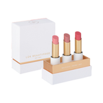 Luk Beautifood Buttery Pinks Lip Nourish Trio on white: Guava Blush, Pink Juniper and Ruby Grapefruit lipsticks standing in an open white and gold presentation box beside its lid.