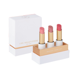 Luk Beautifood Buttery Pinks Lip Nourish Trio on white: Guava Blush, Pink Juniper and Ruby Grapefruit lipsticks standing in an open white and gold presentation box beside its lid.