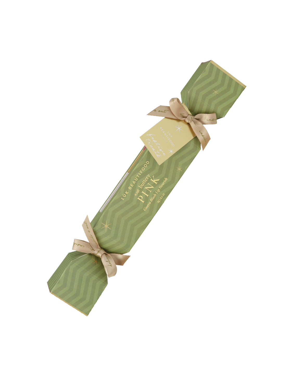 Single Luk Beautifood Guava Blush lip bonbon, a light green Christmas cracker with gold ribbon bows and a gift tag, shown diagonally on white. The packaging reads Soft Buttery Pink.